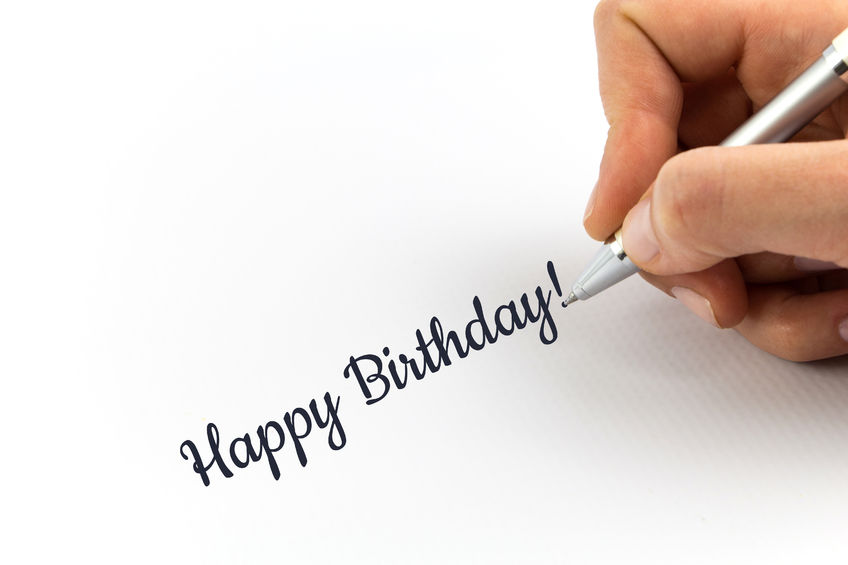 50474492 – hand writing “happy birthday” on white sheet of paper ...